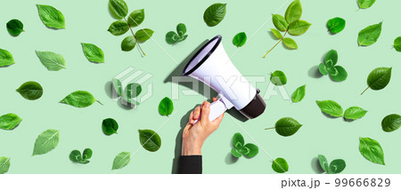 Person holding a megaphone with green leaves 99666829