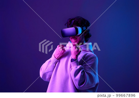 man in vr glasses and sweatshirt plays on blue background. 99667896
