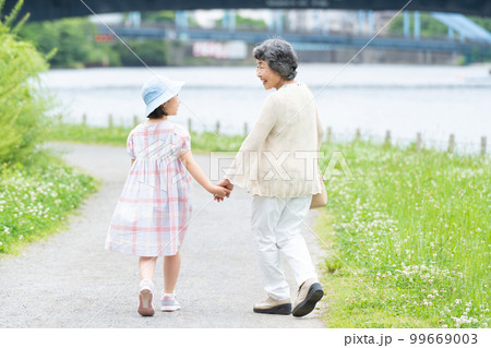 手をつないで歩く女の子とお婆ちゃん 手をつないで歩く女の子とお婆ちゃん 99669003