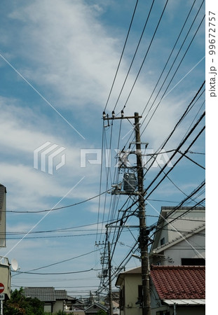 様々なケーブルや電線とそれらを支える電柱 様々なケーブルや電線とそれらを支える電柱 99672757