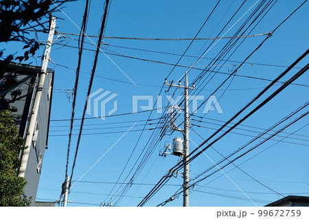 様々なケーブルや電線とそれらを支える電柱 様々なケーブルや電線とそれらを支える電柱 99672759