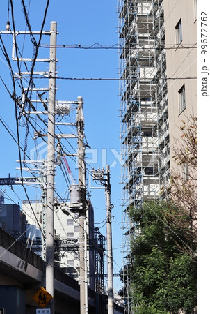 様々なケーブルや電線とそれらを支える電柱 様々なケーブルや電線とそれらを支える電柱 99672762