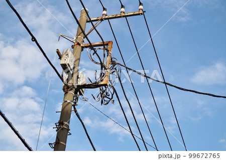 様々なケーブルや電線とそれらを支える電柱 99672765
