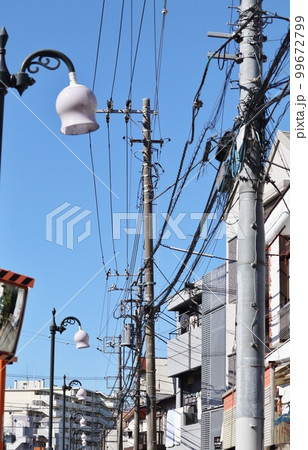 様々なケーブルや電線とそれらを支える電柱 99672799
