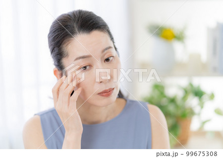 目尻の皺を気にするミドルエイジの女性 99675308