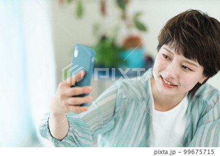 スマートフォンを操作する若い女性 スマートフォンを操作する若い女性 99675715
