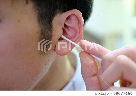 綿棒で耳かきをする男性の耳元 綿棒で耳かきをする男性の耳元 99677160