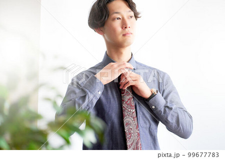 ペイズリー柄ネクタイを締める若い男性 ビジネスカジュアル ドレスアップ イメージ ペイズリー柄ネクタイを締める若い男性 ビジネスカジュアル ドレスアップ イメージ 99677783