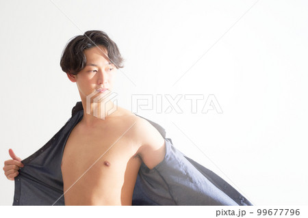 シャツを脱いで素肌を見せる若い男性　メンズビューティー　ライフスタイル　イメージ 99677796