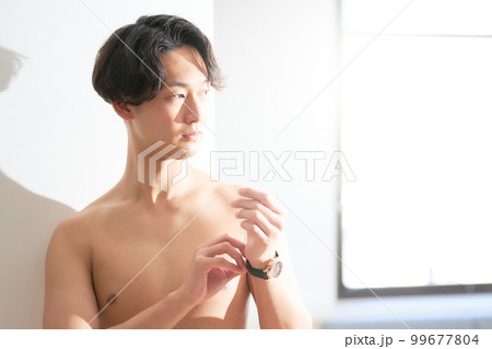 腕時計を外す上半身裸の若い男性　メンズビューティー　ライフスタイル　イメージ 99677804