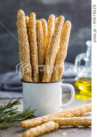 Italian grissini bread sticks with sesame seeds on kitchen table. 99678029