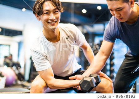 ジムで笑顔でトレーニングをする若い男性 99678192