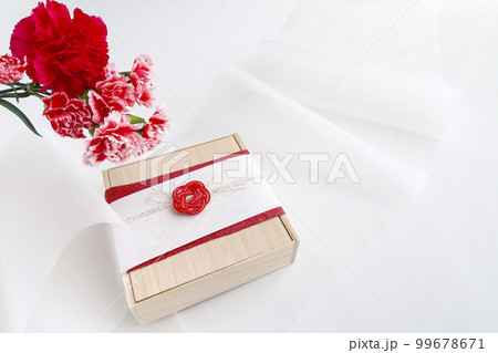 カーネーションの花束と和風ラッピングをしたプレゼント 99678671