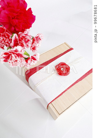 お礼の気持ちを込めた年賀状素材　カーネーションの花束と和風ラッピングをしたプレゼント 99678681
