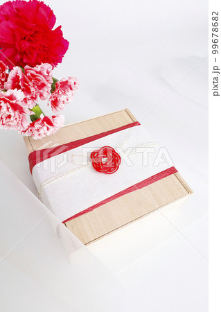 お礼の気持ちを込めた年賀状素材　カーネーションの花束と和風ラッピングをしたプレゼント 99678682