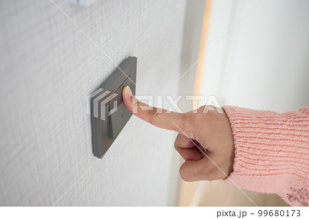 A finger turning on lighting switch . A finger turning on lighting switch . 99680173