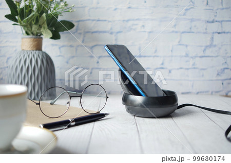 charging Smartphone using Wireless Charging Pad, top view  99680174