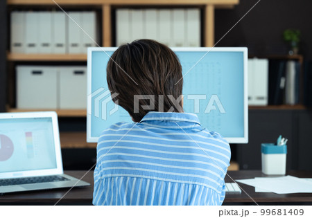 オフィスで働く若い女性の後ろ姿 オフィスで働く若い女性の後ろ姿 99681409