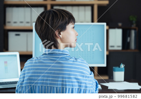 オフィスで働く若い女性の横顔 オフィスで働く若い女性の横顔 99681582