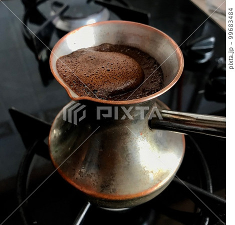 Barista preparing hot tasty drink from copper turk 99683484