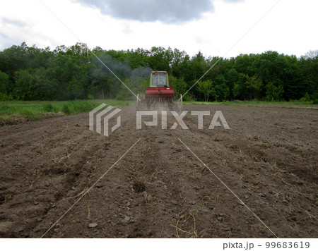 Plowed field by tractor in brown soil on open countryside nature 99683619