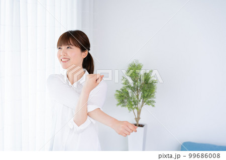 朝日を浴びながらストレッチをする女性 99686008