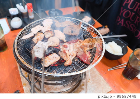 焼き上がった肉をトングで取り分けている様子 99687449