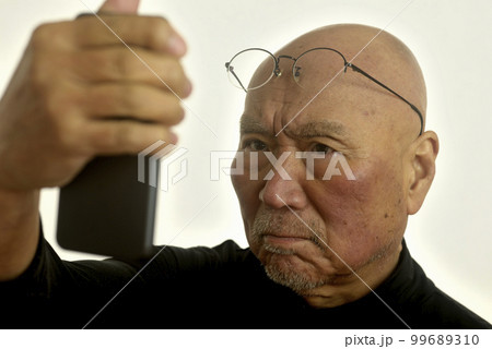 老眼のシニアがスマートフォンを見てます 99689310