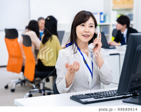 オフィスで固定電話を使う女性 99689914