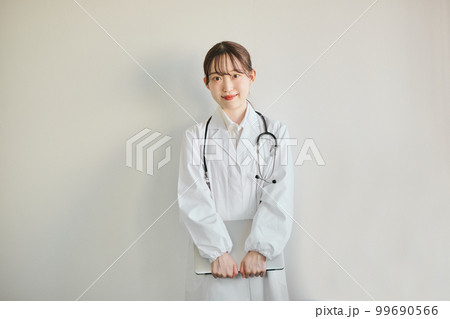 パソコンを持って立つ若い女性医師 パソコンを持って立つ若い女性医師 99690566