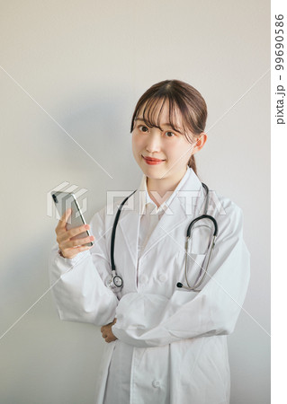 スマートフォンを操作する女性医師 スマートフォンを操作する女性医師 99690586