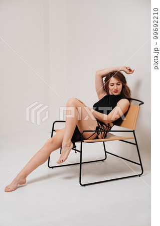 a long-haired woman in a black sexy tight dress with a lace on her thigh 99692210
