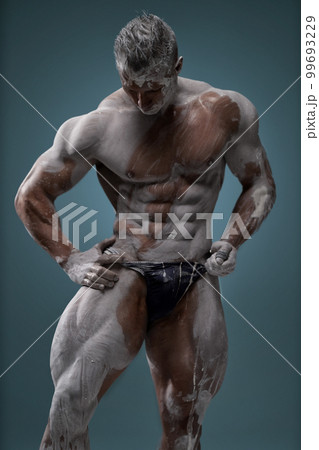 Muscular man touching himself, male posing in studio Muscular man touching himself, male posing in studio 99693229