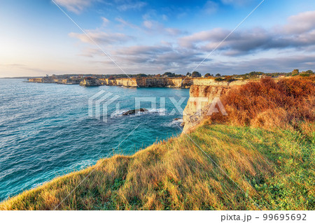 Stunning seascape with cliffs rocky arch and stacks (faraglioni) at Torre Sant Andrea Stunning seascape with cliffs rocky arch and stacks (faraglioni) at Torre Sant Andrea 99695692