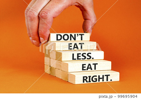 Eat less or right symbol. Concept words Do not eat less, eat right on wooden blocks. Beautiful orange table orange background. Doctor hand. Healthy lifestyle and eat less or right concept. Copy space. 99695904