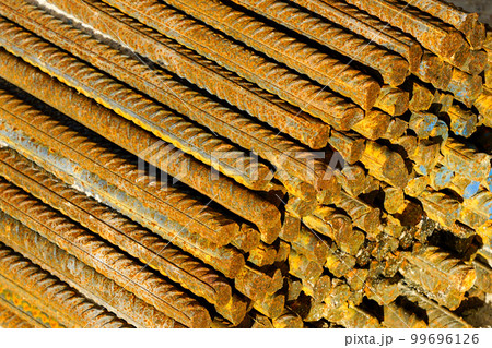 A slightly rusted bundle of steel reinforcing bars stored at a construction site 99696126