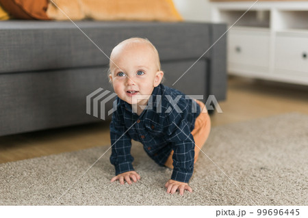 Nursery baby boy crawling on floor indoors at home copy space and empty space for text - Baby curiosity and child development stages Nursery baby boy crawling on floor indoors at home copy space and empty space for text - Baby curiosity and child development stages 99696445