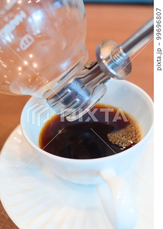 サイフォン式ホットコーヒーを注いでいるシーン サイフォン式ホットコーヒーを注いでいるシーン 99696807