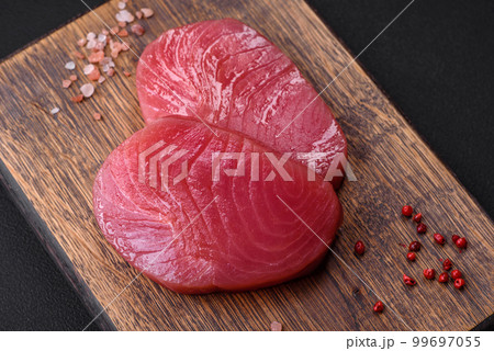 Two fresh slices of raw tuna fillet with spices and herbs 99697055