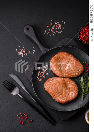 Two baked slices of tuna fillet with spices and herbs Two baked slices of tuna fillet with spices and herbs 99697176