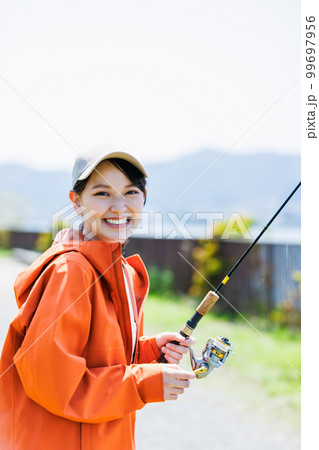 趣味の釣りを楽しむ笑顔の若い女性 99697956