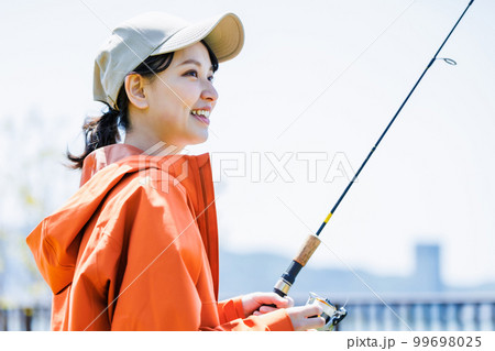 趣味の釣りを楽しむ笑顔の若い女性 趣味の釣りを楽しむ笑顔の若い女性 99698025