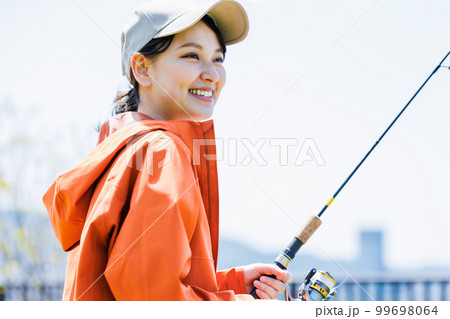 趣味の釣りを楽しむ笑顔の若い女性 趣味の釣りを楽しむ笑顔の若い女性 99698064