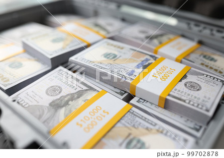 Briefcase full of stacks of dollar bills, pile of cash 99702878