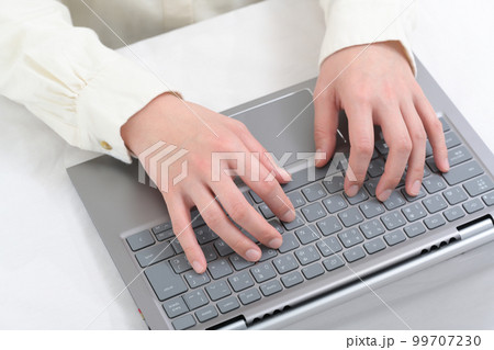 ノートパソコンのキーボードを操作する女性の手元 99707230