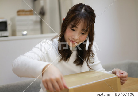 ダンボールの大きさを測る女性 99707406