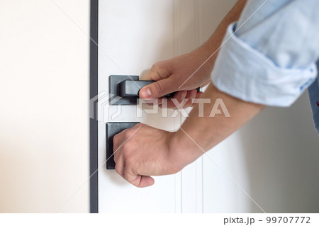 Men's hands open the door lock in the house Men's hands open the door lock in the house 99707772