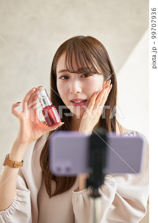 ライブ配信で化粧品の販売をする女性 99707936
