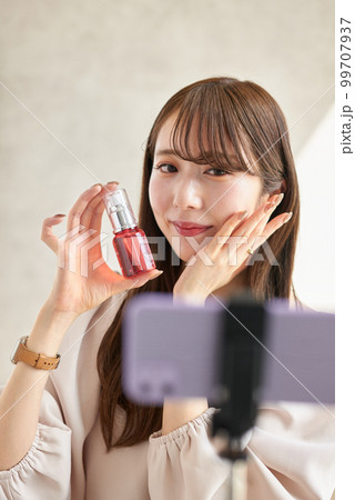 ライブ配信で化粧品の販売をする女性 99707937