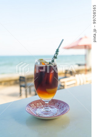 iced americano coffee peach with sea background 99708565